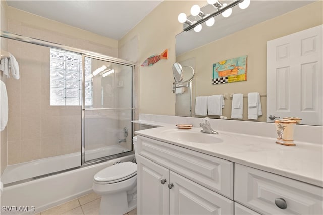 full bathroom with shower / bath combination with glass door, tile patterned flooring, vanity, and toilet