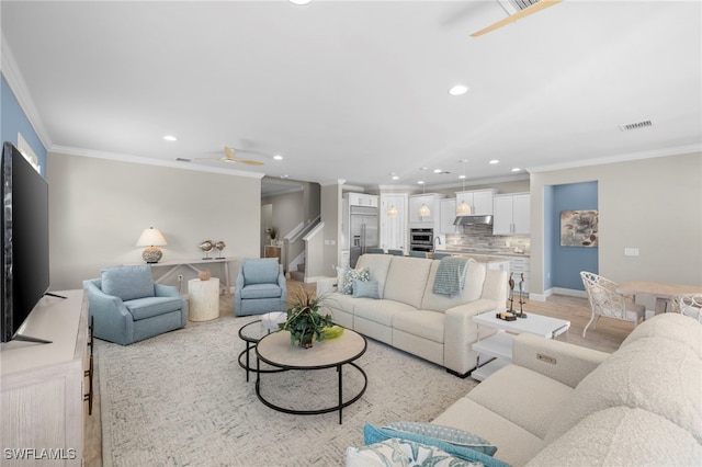 living room with ceiling fan, light hardwood / wood-style floors, and crown molding