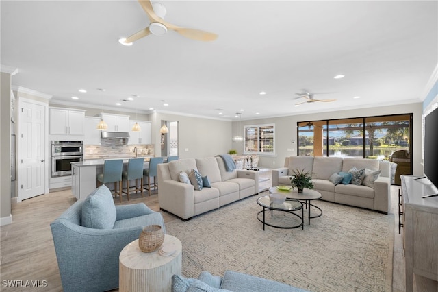 living room featuring ceiling fan, light hardwood / wood-style floors, sink, and crown molding