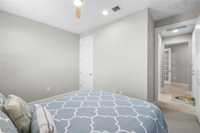 carpeted bedroom featuring ceiling fan and a closet