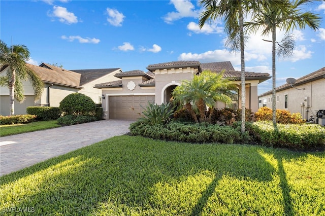 mediterranean / spanish-style house with a garage and a front lawn