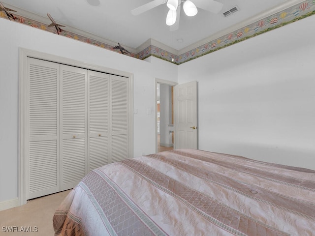 bedroom with ceiling fan, a closet, and light colored carpet