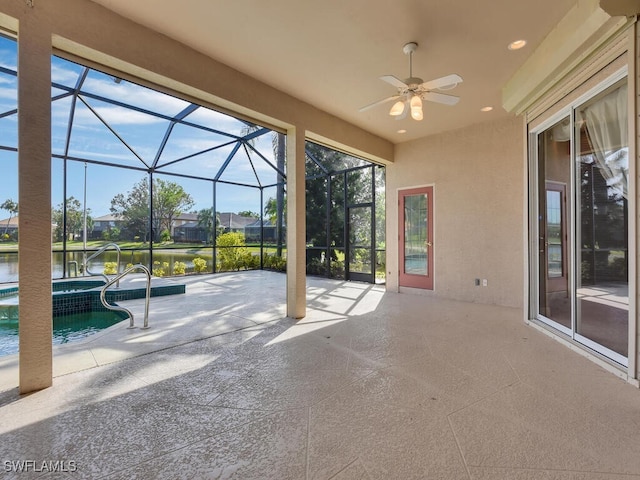 view of patio / terrace with a water view, glass enclosure, and ceiling fan