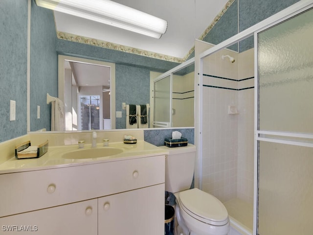 bathroom featuring toilet, vanity, and walk in shower