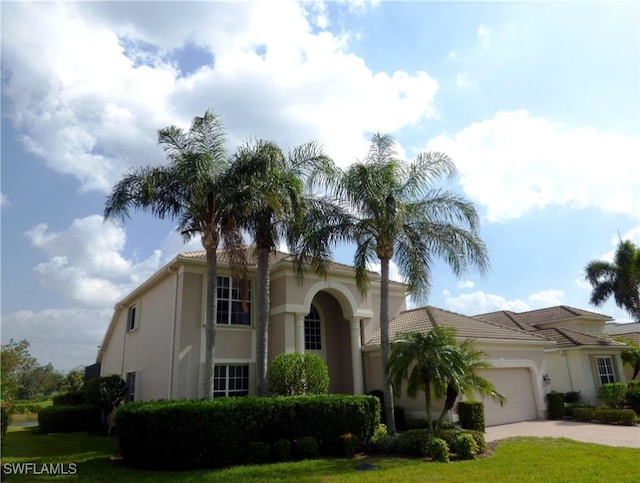 mediterranean / spanish-style home with a garage and a front yard