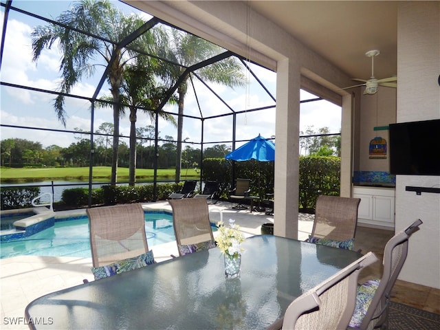 view of pool with a lanai, a water view, ceiling fan, and a patio