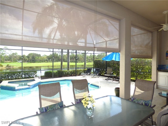 view of swimming pool with an in ground hot tub, a patio area, a water view, a lanai, and ceiling fan