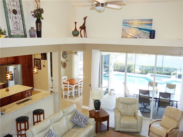 living room featuring light tile patterned flooring, ceiling fan, and sink