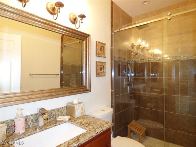 bathroom with walk in shower, vanity, and toilet