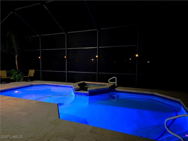 pool at twilight with a patio, a lanai, and an in ground hot tub