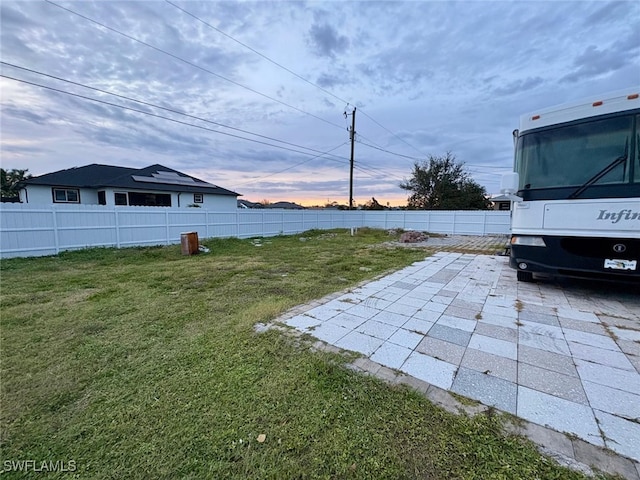 yard at dusk featuring a patio