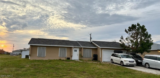 single story home featuring a lawn and a garage