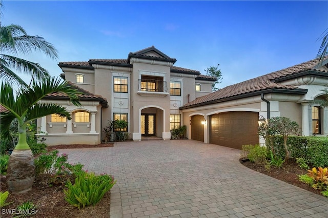 mediterranean / spanish-style house with a garage and a balcony