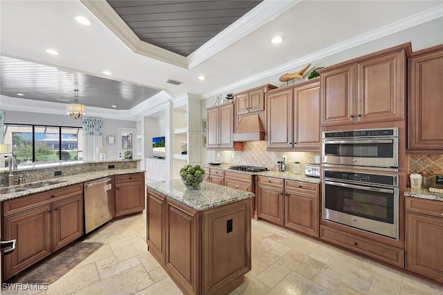 kitchen featuring stainless steel appliances, crown molding, sink, decorative light fixtures, and a kitchen island