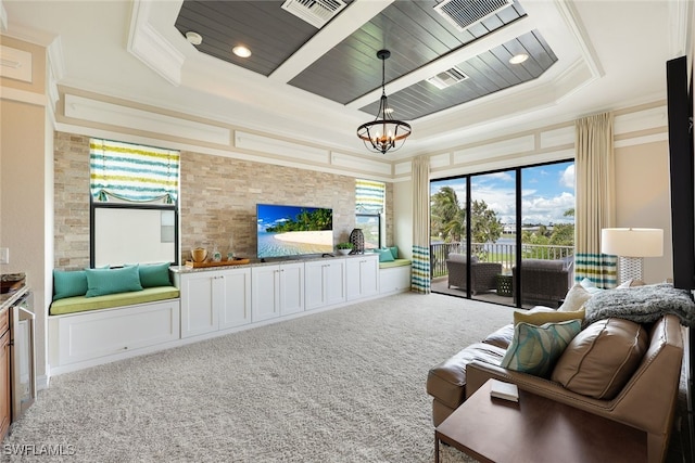 living room featuring a raised ceiling, carpet floors, ornamental molding, and an inviting chandelier