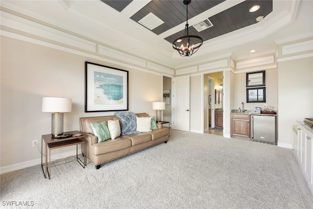 carpeted living room featuring a tray ceiling, an inviting chandelier, and ornamental molding