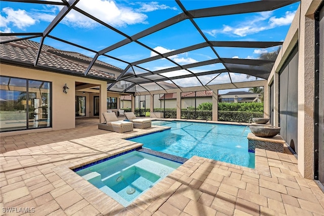 view of pool featuring an in ground hot tub, a patio, and glass enclosure