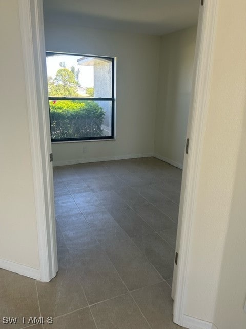 unfurnished room featuring dark tile patterned floors