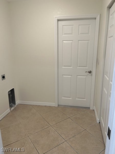 washroom with hookup for an electric dryer and light tile patterned floors