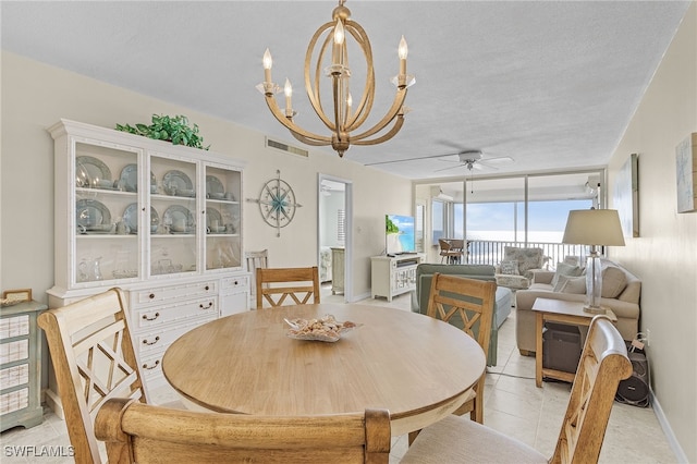 tiled dining room with a textured ceiling and ceiling fan with notable chandelier