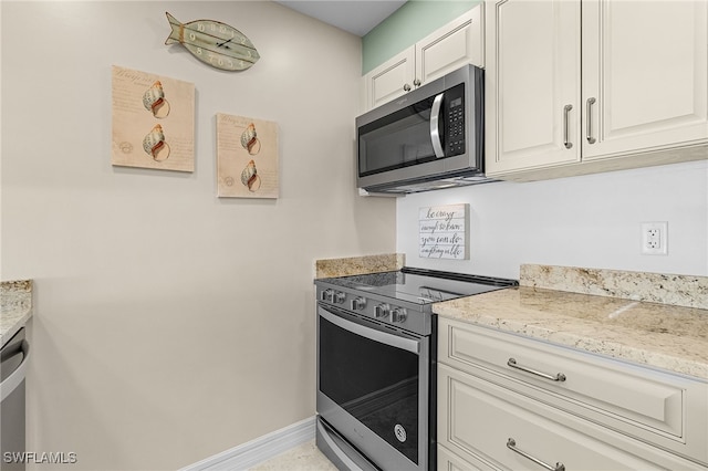 kitchen featuring white cabinetry, light stone counters, and stainless steel appliances