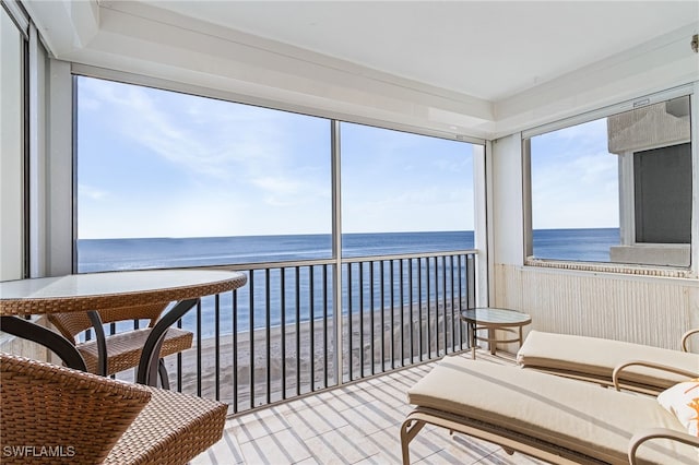 sunroom / solarium with a view of the beach and a water view