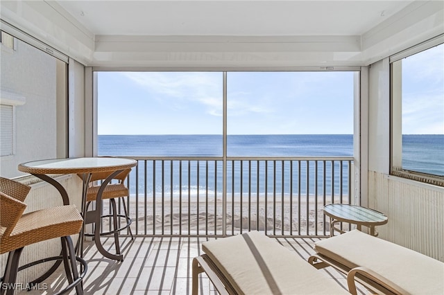 sunroom with a water view and a view of the beach