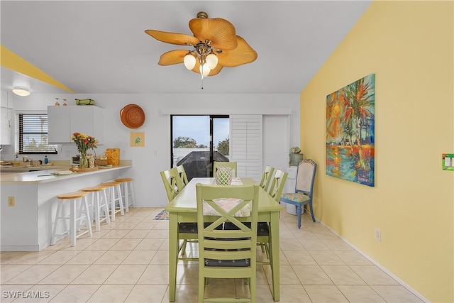 tiled dining room with ceiling fan, a wealth of natural light, and vaulted ceiling