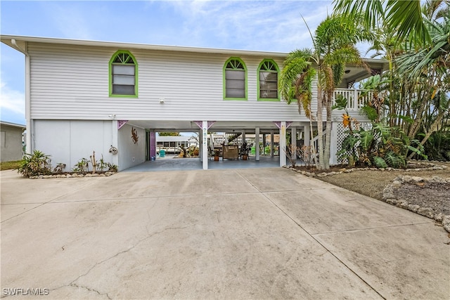 raised beach house with covered porch and a carport