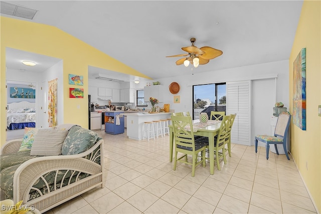 tiled dining area with ceiling fan and vaulted ceiling