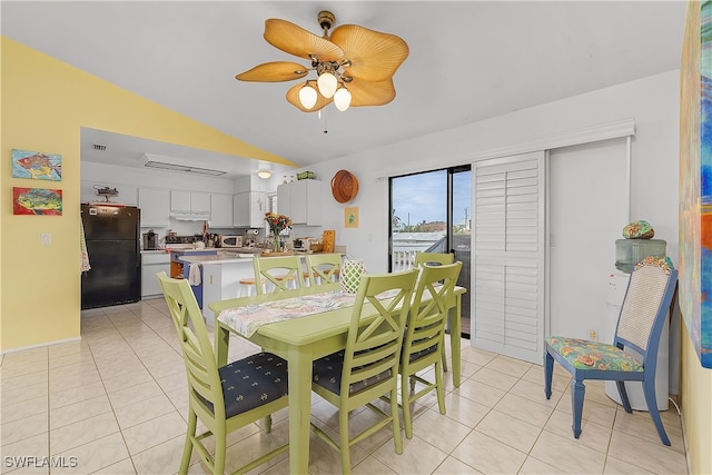 tiled dining room with ceiling fan and lofted ceiling