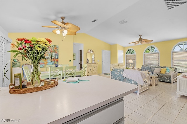 bedroom with ceiling fan, light tile patterned floors, and vaulted ceiling