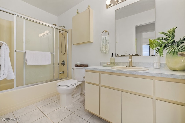 full bathroom with combined bath / shower with glass door, tile patterned floors, vanity, and toilet