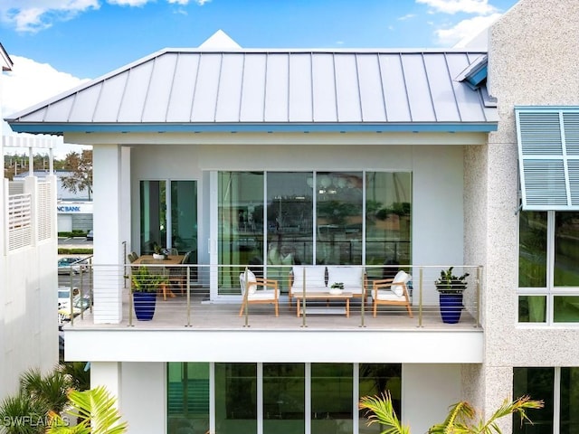 back of house featuring an outdoor living space and a balcony