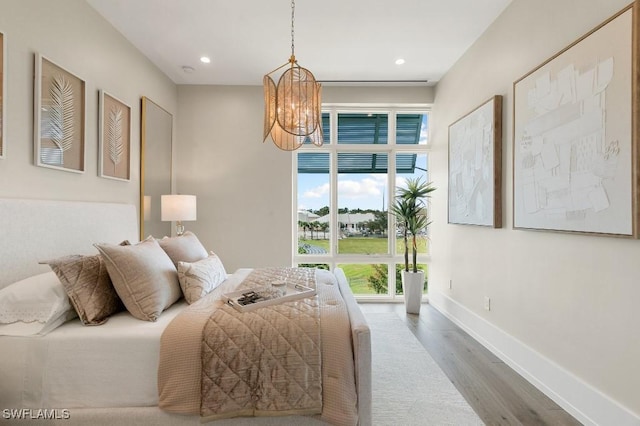 bedroom featuring hardwood / wood-style flooring and a chandelier