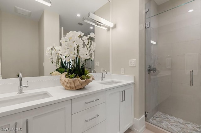 bathroom featuring a shower with door and vanity