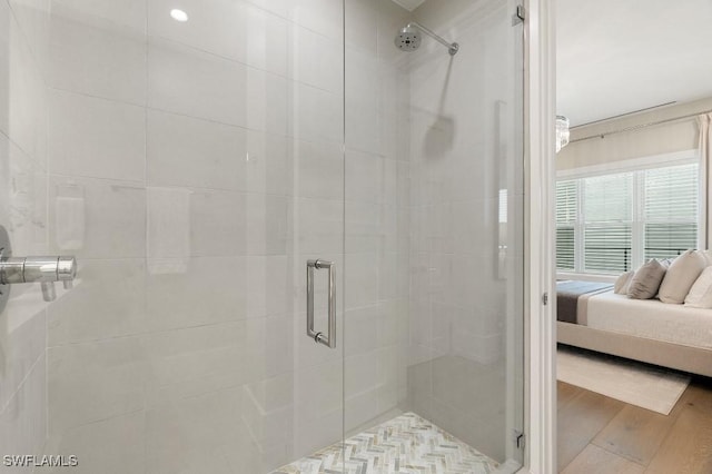 bathroom with hardwood / wood-style floors and a shower with door