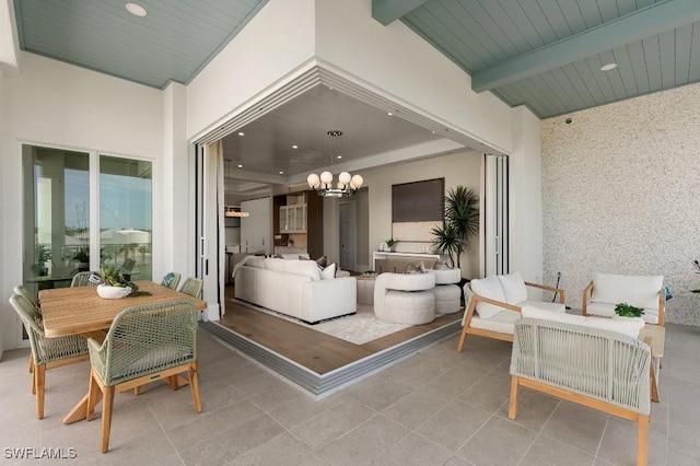 sunroom with beam ceiling, an inviting chandelier, and wooden ceiling