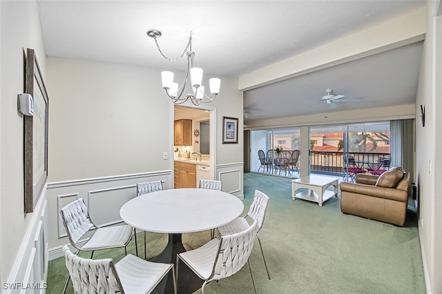 carpeted dining room with beamed ceiling, ceiling fan with notable chandelier, and sink