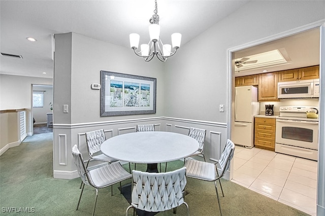 dining area featuring light tile patterned floors and ceiling fan with notable chandelier