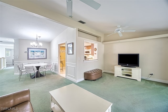 living room with carpet flooring, ceiling fan with notable chandelier, and vaulted ceiling