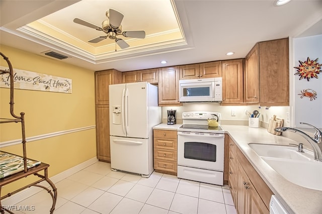 kitchen featuring white appliances, crown molding, sink, ceiling fan, and a tray ceiling