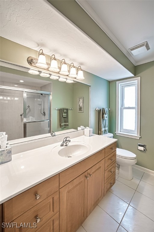 bathroom featuring walk in shower, tile patterned floors, crown molding, toilet, and vanity