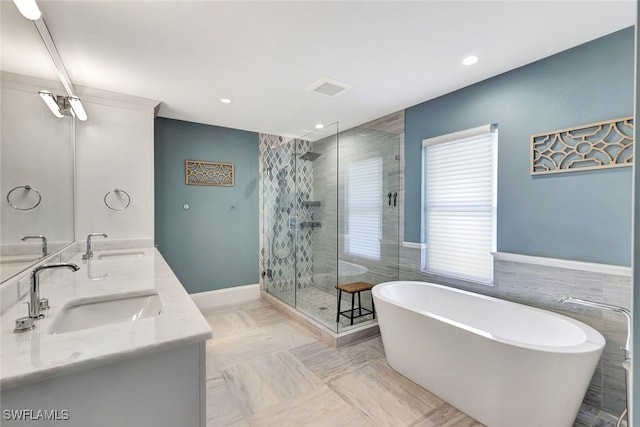 bathroom featuring vanity, tile walls, and separate shower and tub