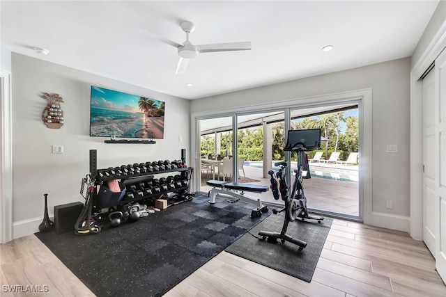 exercise area with light hardwood / wood-style flooring and ceiling fan