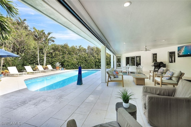 view of pool with an outdoor living space, a patio area, and ceiling fan