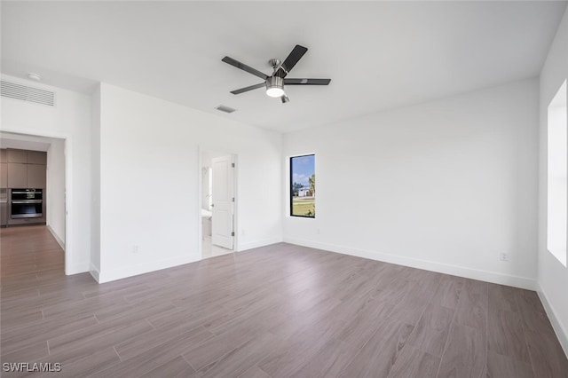 empty room with ceiling fan and light hardwood / wood-style floors