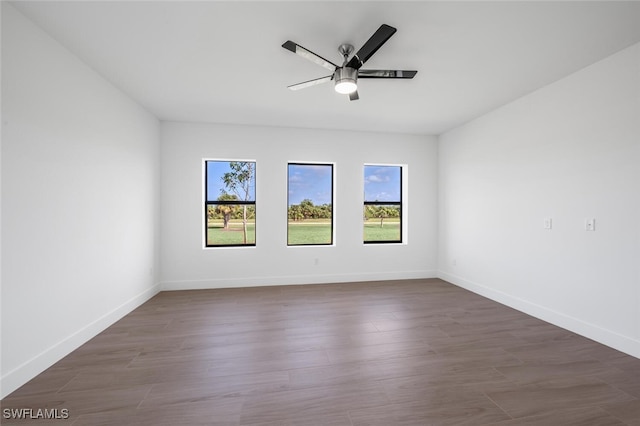 empty room with dark hardwood / wood-style flooring and ceiling fan