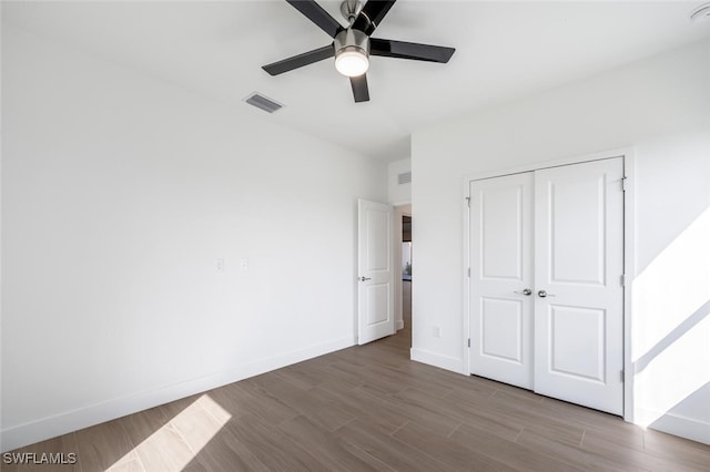 unfurnished bedroom with ceiling fan, a closet, and light wood-type flooring