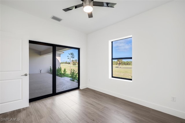 spare room with plenty of natural light, light hardwood / wood-style floors, and ceiling fan